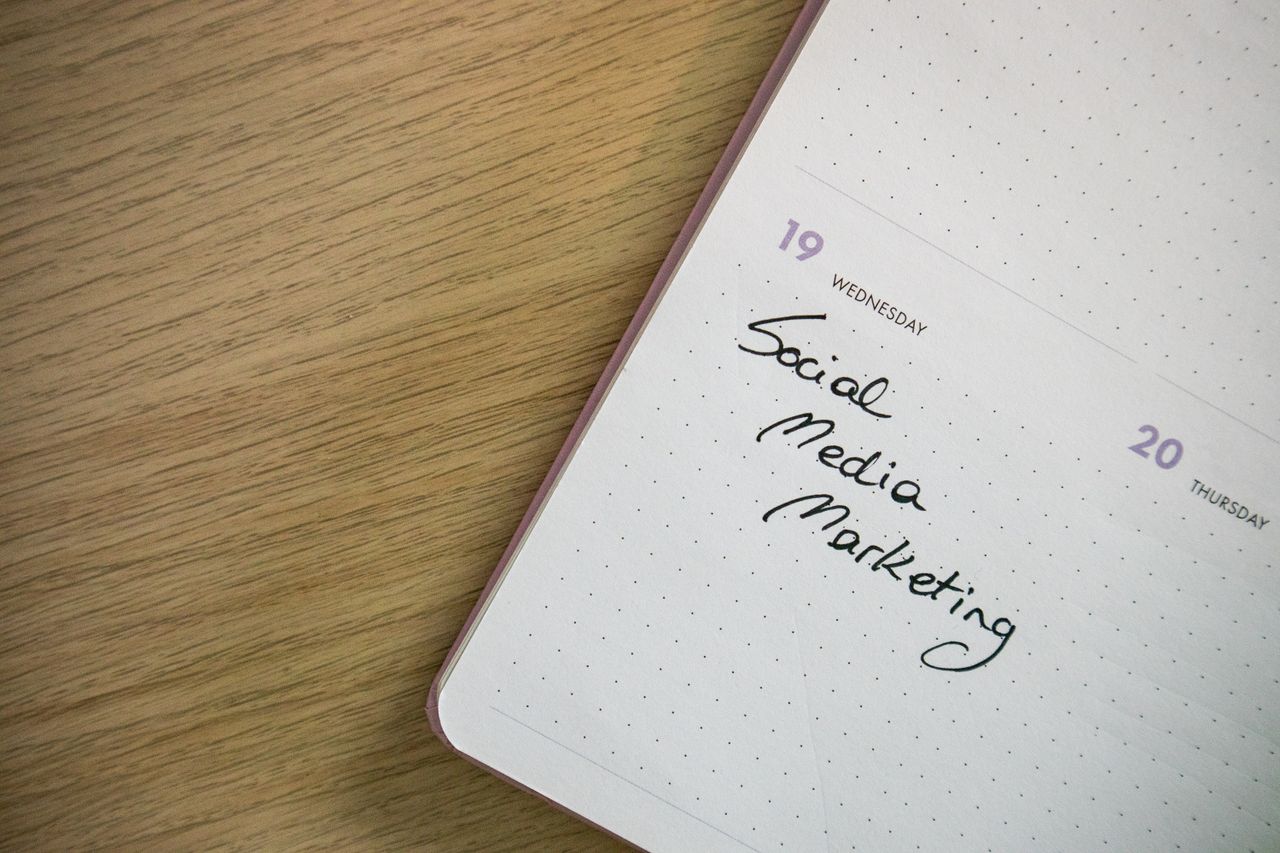 team-03 Close-up of a notebook page with Social Media Marketing handwritten on it.